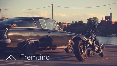 Bil og mc parkert foran et vann